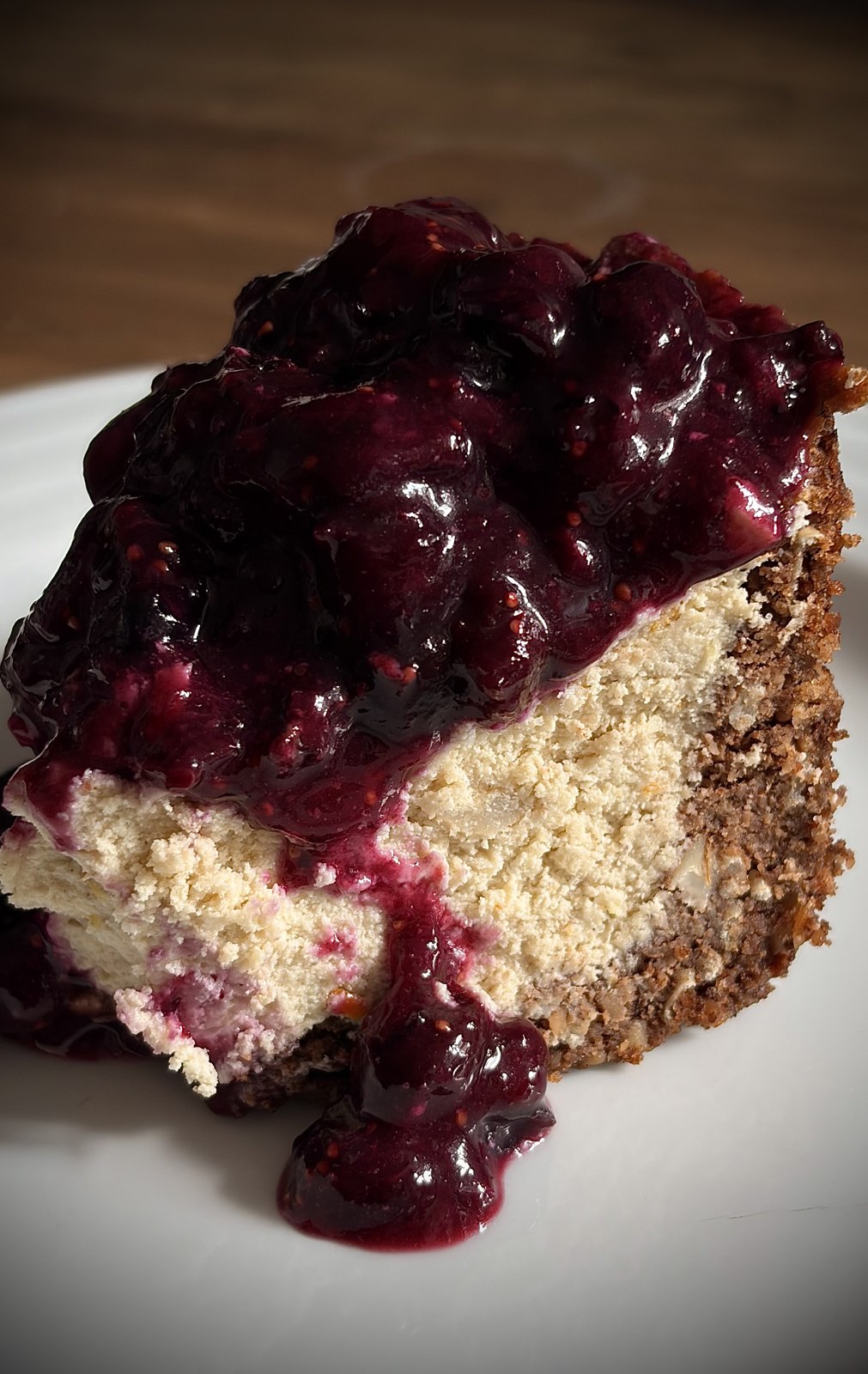 A slice of BluBerry cheesecake with a blueberry and fig crown