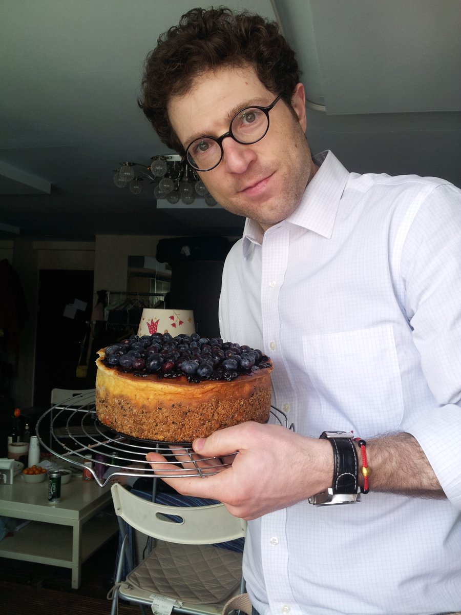 The baker holding an early BluBerry cheesecake